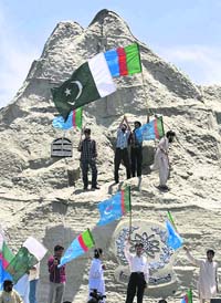 Activists of Jamat-i-Islami wave Pakistani and their party flags at the model of Chaghi mountain, the site of Pakistans nuclear test, on Wednesday.