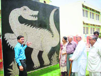 Rajesh Kumar with his creation, a dinosaur, made of used blades.