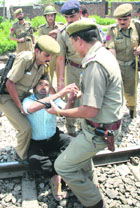 Policemen trying to take away a protesting Gujjar from the railway track in Jammu on Thursday.