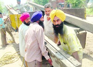 Farmers load poles to be taken to villages in Morinda for installing transformers. The farmers were denied benefit of OYT scheme after they invested lakhs for it. 