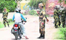 A securityman questions a man entering violence-hit Pattikalyana village, near Panipat, on Friday. 