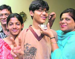 IIT district topper Hitesh Jain being offered sweets by family members on Friday in Ludhiana. 