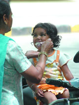 A mother feeds ice-cream to her child in New Delhi on Sunday.