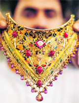 A Kashmiri shopkeeper displays a gold necklace at his showroom in Srinagar on Monday.