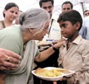 Chief Minister Sheila Dikshit serves lunch to a child during the launch of Aap Ki Rasoi at Hanuman Mandir in New Delhi on Monday.