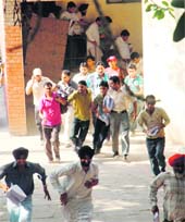 Shopkeepers rush out with the gazette of the result of Class XII examination in Ludhiana on Monday.