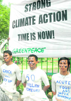 Greenpeace activists pose with painted torsos sporting climate change messages during a protest in New Delhi on Monday.
