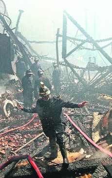 A fireman gives instructions at the scene of a fire in a residential area in Mumbai on Monday.