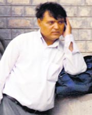 Satish Kumar with the bagful of prospectuses talks on the phone in front of the SBI cash counter