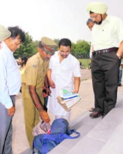 PU security personnel open his bag and find prospectuses inside while registrar Prof S S Bari looks on