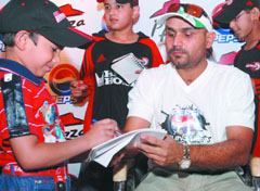 Cricketer Virender Sehwag gives autographs to children at a restaurant in New Delhi on Tuesday.