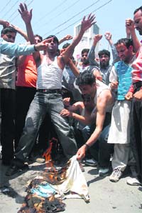 Members of the Jammu and Kashmir Unemployed ITI Electrician Diploma Holders Association burn clothes during a demonstration against the state government in support of their demands, in Srinagar on Tuesday.