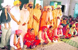 Jagdish Singh Garcha and other leaders pose with newly wed couples in Brahampur village near Ahmedgarh on Tuesday.