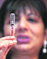Chairman and managing director of Biocon Limited, Kiran Mazumdar Shaw shows a newly launched prefilled syringe safety device for two of its lifesaving drugs for kidney and cancer patients, in Bangalore on Wednesday.