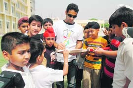 Gagandeep Singh of IPLs Kings XI Punjab signs autographs for students of MGM School in Ludhiana on Wednesday.