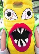 An environmentalist dressed in a corn costume participates in a rally denouncing the imports of genetically modified corn in front of the Integrated Government Complex in Seoul