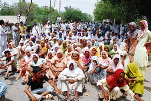Kin of two Congress men, Hargobind Singh and Swaran Singh, staging protest at village Bhai Bakhtaur on Thursday. 