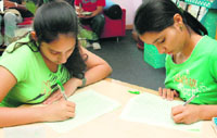Girls take part in a writing competition on Environment Day at the British Library in Chandigarh on Thursday.
