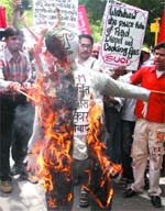 Activists of the Socialist Unity Centre of India (SUCI) burn an effigy of Prime Minister Dr Manmohan Singh during a protest against petro price hike at Jantar Mantar in New Delhi on Thursday.