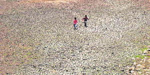 Children run on a dried lakebed in Hyderabad on Thursday.