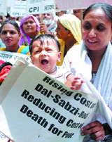 Activists of the CPI protest against the hike in fuel prices and the rising prices of essential commodities at ITO in New Delhi on Friday.