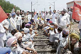 CPM activists block rail traffic on the Rajpura-Ambala line against rising prices at Rajpura on Sunday. 