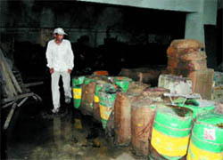 Employees inspect the godown of the Central Warehousing Corporation in New Delhi that caught fire on Sunday.