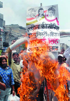 Activists of the Nagarik Samiti shout slogans and burn the effigies of Prime Minister Manmohan Singh, Congress President Sonia Gandhi and CPM general secertary Prakash Karat against the price hike in petroleum products and essential commodities at Sadar Bazar, in New Delhi on Sunday.