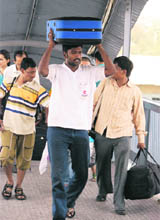 Passengers carry their own luggage at the Jammu railway station.