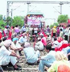 Activists of CPM, CITU, along with representatives of farmers and farm workers, resort to rail roko at Dhandari railway station in Ludhiana on Sunday.