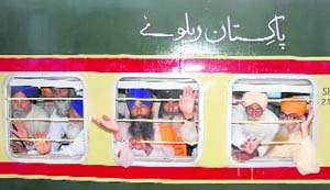 Devotees wave as they leave Amritsar on Sunday by a special train for Pakistan to observe the martyrdom day of Guru Arjan Dev. 