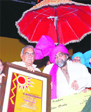 Haryana Chief Minister Bhupinder Singh Hooda honours advertising guru Prahlad Kakkar during an award ceremony organised by the Haryana Institute of Fine Arts in Karnal on Monday.