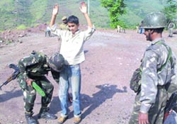 Army personnel frisking a young boy at a mobile checkpoint near Shindra in Poonch district