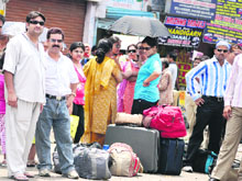 Passengers wait outside the bus stand at Jammu on Tuesday.
