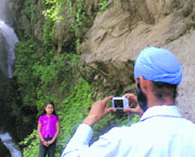 A tourist clicking a picture of a young girl at Noori Chamb in Poonch.