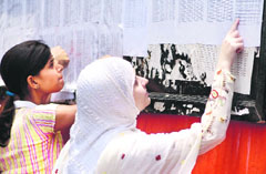 Girl students watching the merit list for admission to various colleges at Jammu on Tuesday.
