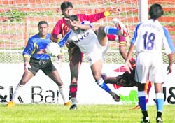 Players of hosts Jammu and Kashmir (Blue) and Services in action during their quarter-final match at the 62nd Santosh Trophy National Football Championship at Bakshi Stadium in Srinagar