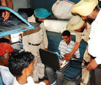 Security personnel searching passengers luggage in a train at Bathinda railway station on Wednesday.