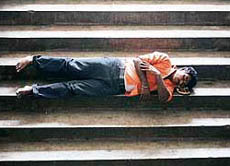 A stranded passenger takes a nap on stairs at a bus terminal in Jammu on Wednesday.