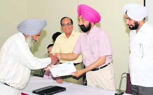 PSEB engineer-in-chief (Central Zone) B.S. Bath gives a certificate to a staff member on the concluding day of the three-day training programme in Ludhiana on Wednesday. 