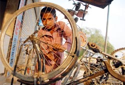 An 11-year-old repairs cycles to earn his livelihood at a village in Bathinda district.