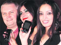 Chief executive officer Mobile and Wireless Group (MWG) Mark Billington (L) with models at the launch of MWGs new Windows mobile handsets in New Delhi on Thursday. The handsets, Atom V and Zinc II, are priced at Rs 27,888 and Rs 34,888 respectively.