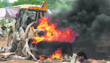 A JCB machine in flames after a clash between agitated dwellers and the police on the second day of the demolition drive at Mansa Devi Complex, Sector 5, Panchkula, on Thursday.