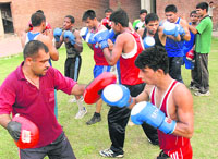 A senior boxer, Om Prakash (left), trains budding boxers for the junior national tournament to be held in Nagpur from June 17 to 22 at Sector-42 sports complex in Chandigarh on Thursday.