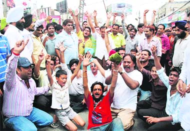 Shopkeepers stage a dharna at the busy Ghumar Mandi-National Road intersection to protest against sealing in Ludhiana on Thursday.
