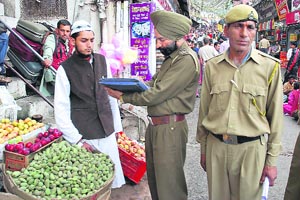 In a bid to rein in encroachments, a fruit vendor is challaned in Lower Bazar at Shimla on Friday. 