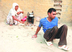 Darshan Kaur with her disabled son in Sandhar village in Hoshiarpur on Friday.