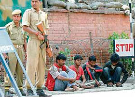 CRPF jawans stand guard over labourers held for questioning following a grenade attack in Srinagar on Saturday.