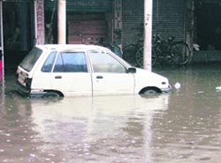 A submerged vehicle and shops in the Bhadaur House market after the rains in Ludhiana on Saturday. 