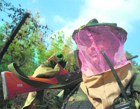 A BSF soldier wears a mask developed by the forces medical unit to prevent mosquito bites as he patrols the Kalatilla area, 198 km northeast of Agartala, on Saturday.